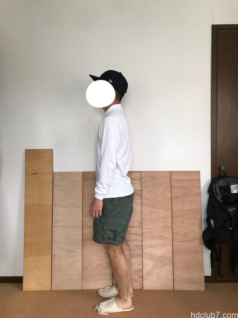 ロールアップしたプロッパーのBDUカーゴショーツとラコステの長袖ポロシャツを着て立っている男