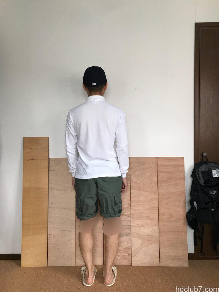 ロールアップしたプロッパーのBDUカーゴショーツとラコステの長袖ポロシャツを着て立っている男