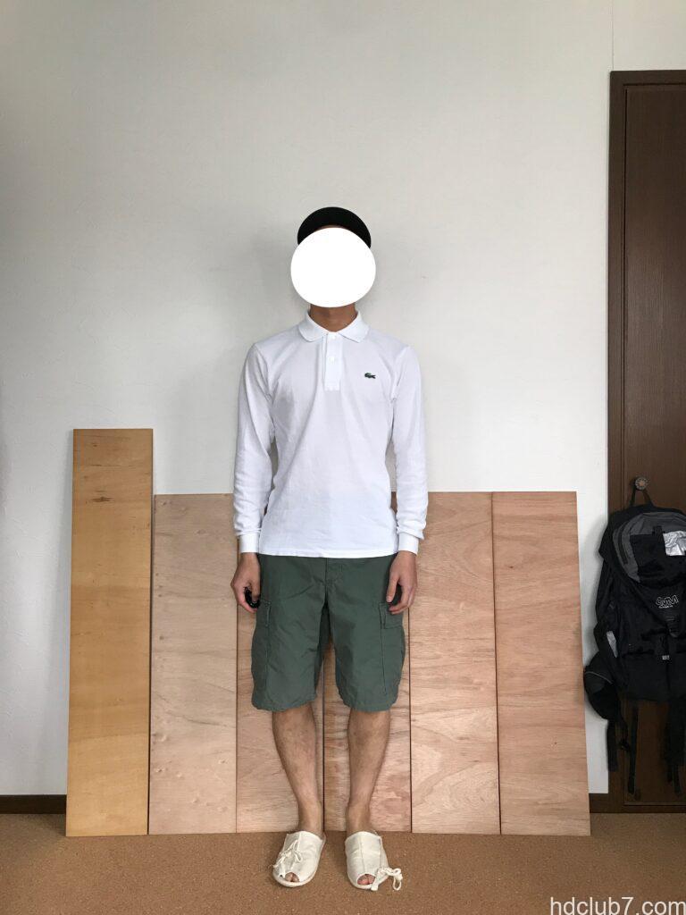 プロッパーのBDUカーゴショーツとラコステの長袖ポロシャツを着て立っている男