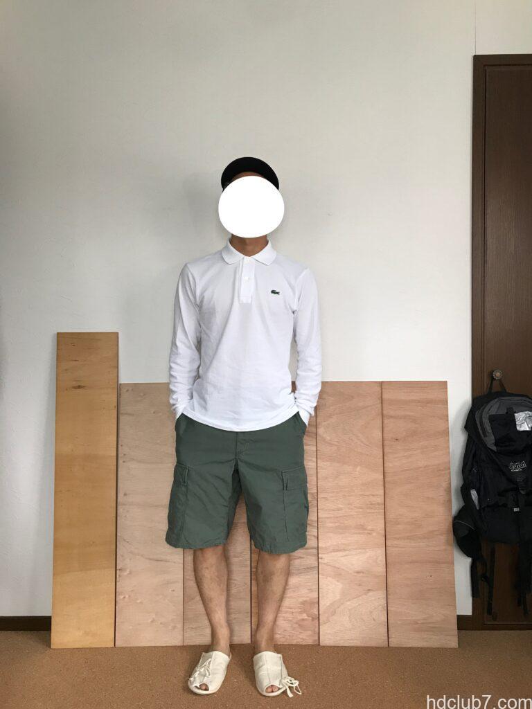 プロッパーのBDUカーゴショーツとラコステの長袖ポロシャツを着て立っている男