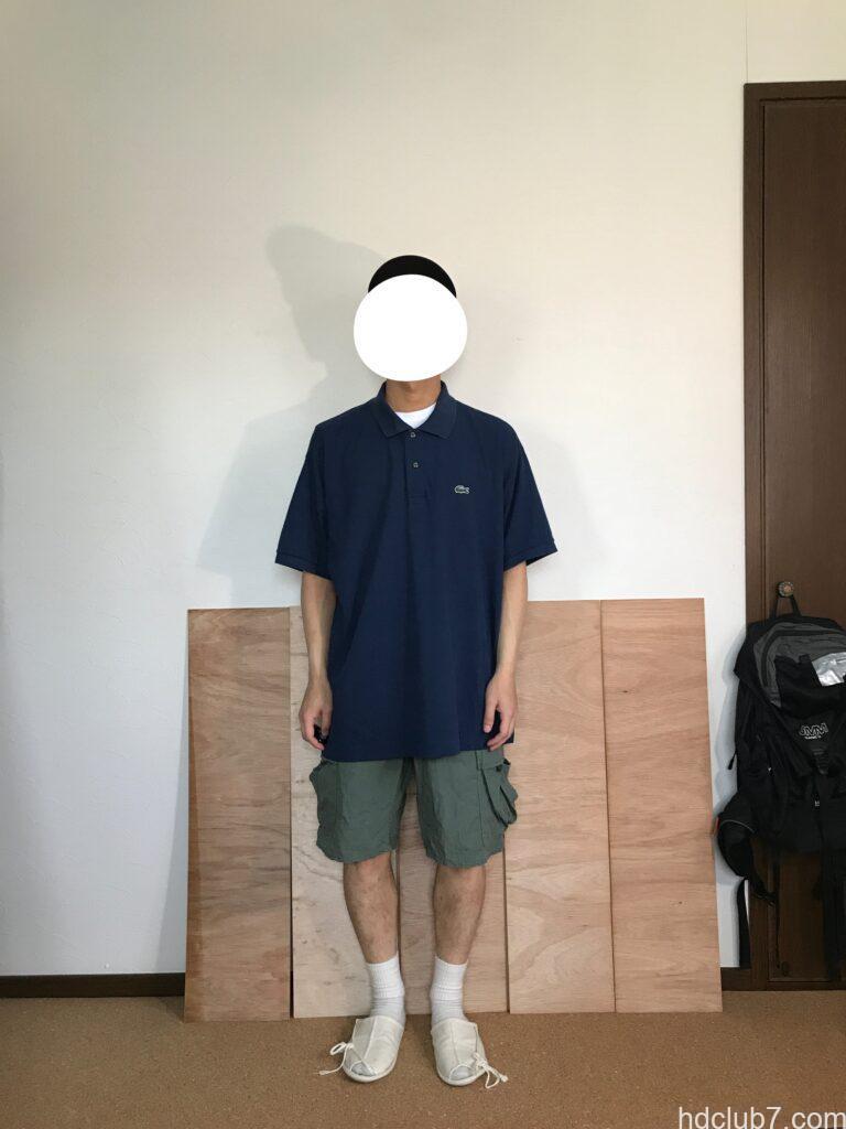 ラコステのポロシャツL1212のオーバーサイズ8とプロッパーのカーゴショーツを着た人