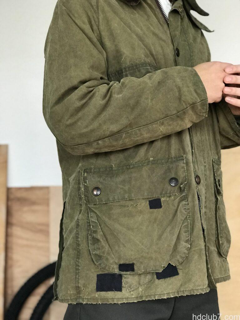 パッチワーク風にリペアされたヴィンテージのバブアーを着た人